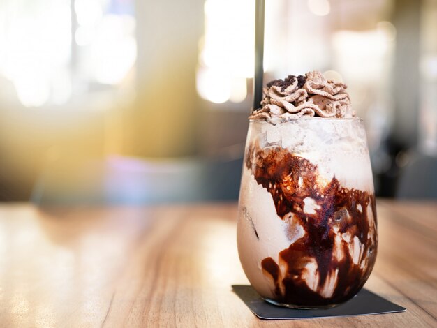 Frapê de chocolate com chantilly acima. coloque na mesa de madeira.