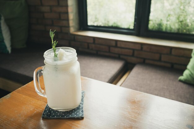 Frappe de agua de coco fresco con hojas de romero en la mesa del restaurante