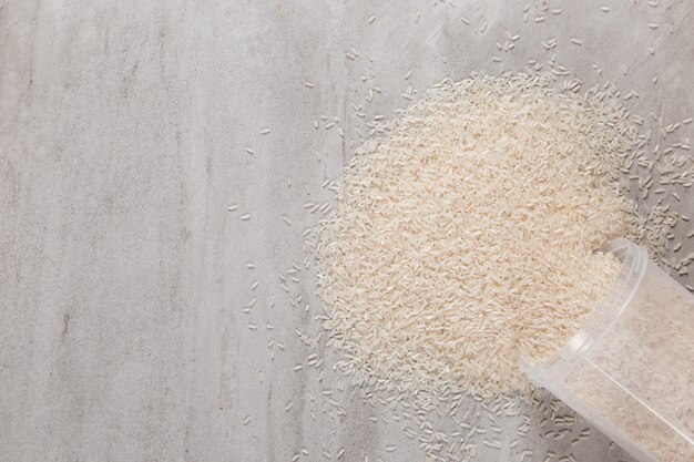 Un frasco de arroz está esparcido sobre una mesa de piedra.