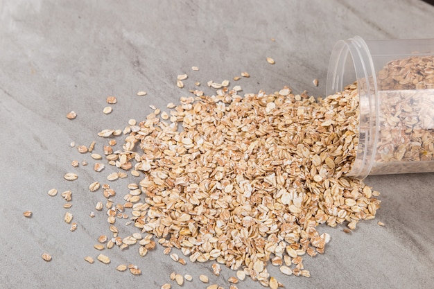 Un frasco de avena está esparcido sobre la mesa.