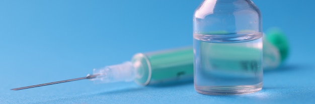 Frasco com medicamento e seringa em azul na clínica