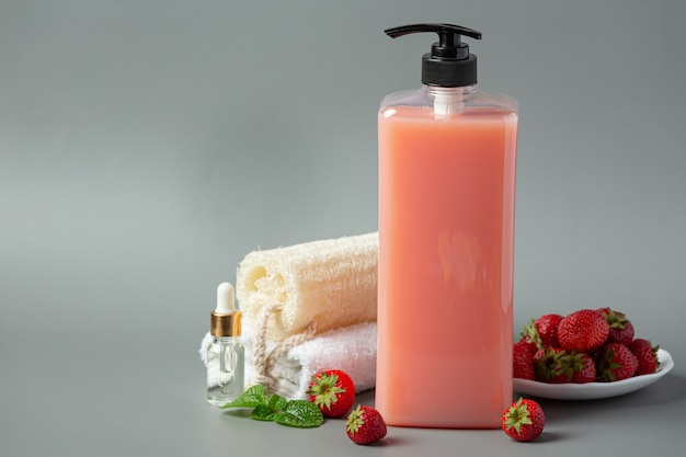 Frasco cosmético com shampoo de morango na superfície cinza