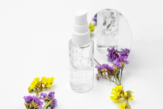 Frasco cosmético com soro e flores