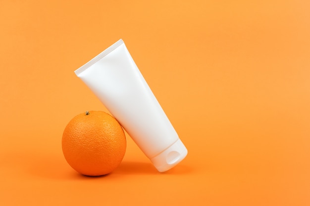 Frasco cosmético em branco branco, tubo de creme, loção para o corpo, rosto ou mão, fruta laranja. Cosmético de conceito com vitamina C, antioxidantes