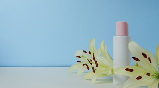 frasco de cosmético branco vazio com creme com tampa rosa, loção hidratante ou xampu emoldurado com lírio