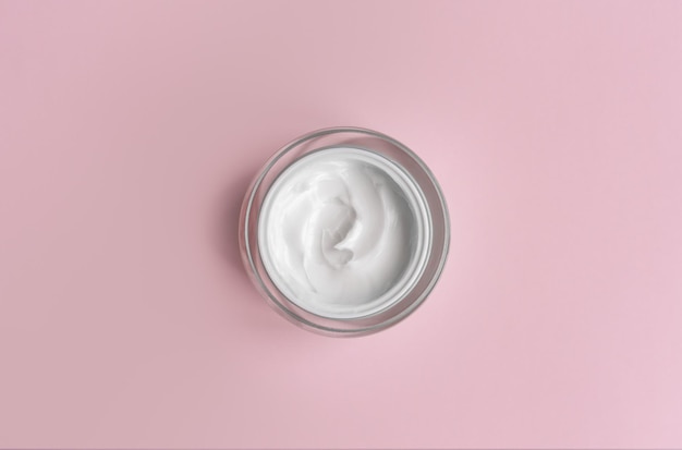 Foto frasco de creme branco em fundo rosa close-up apresentação de cosméticos de beleza hidratantes cuidados com a pele