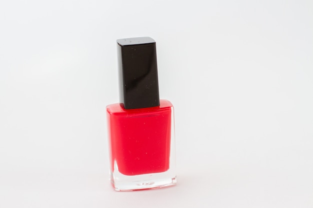 Frasco de esmalte vermelho sobre fundo branco