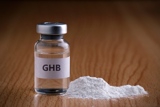 Frasco de ghb com pó de droga na superfície de madeira ghb