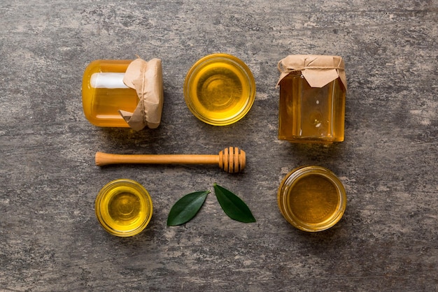 Frasco de mel com concha de mel de madeira na vista superior de fundo branco com espaço de cópia Delicioso frasco de mel