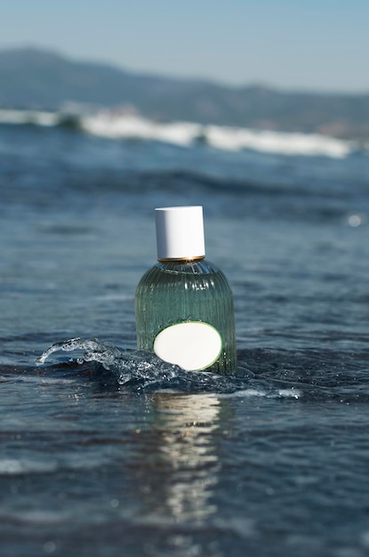 Frasco de perfume azul simulado fica na areia molhada no fundo das ondas e do mar na praia