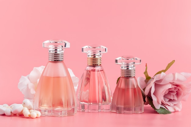 Frasco de perfume com rosas em tecido rosa