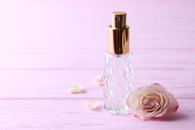 Frasco de perfume e flores rosas em um fundo claro close-up