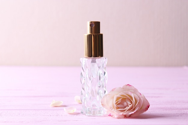 Frasco de perfume e flores rosas em um fundo claro close-up