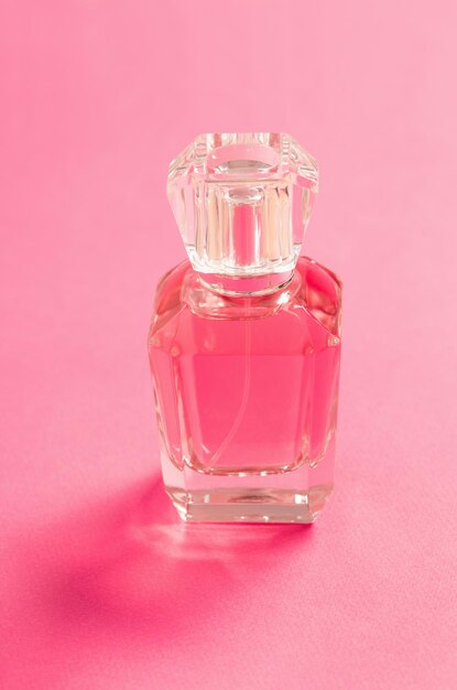 Frasco de perfume em fundo rosa