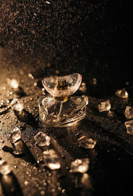 Frasco de perfume em um fundo preto com cubos de gelo gotas de água e respingos jogo de luz