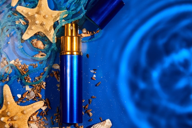 Frasco de perfume plano leigo de fundo de água com mar de estrelas do mar ou conchas oceânicas