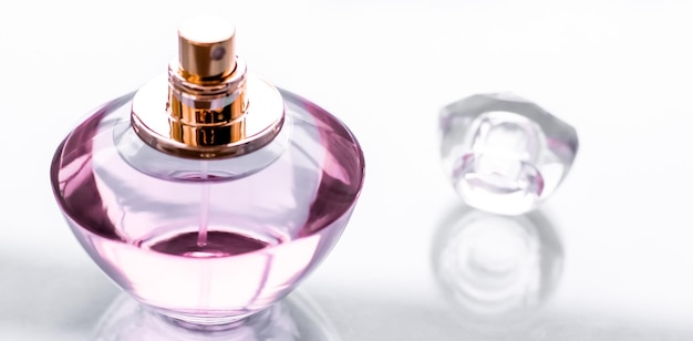 Frasco de perfume rosa em fundo brilhante perfume floral doce glamour fragrância e eau de parfum como presente de feriado e design de marca de cosméticos de beleza de luxo