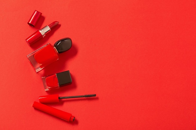 Frasco de perfume vermelho e cosméticos em fundo vermelho