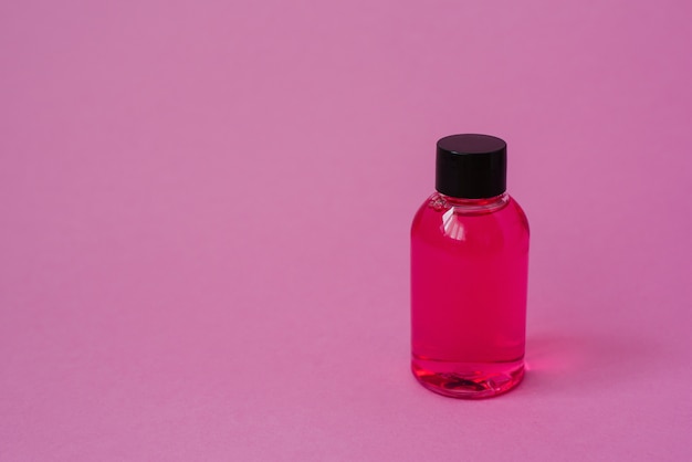 Frasco de produto cosmético para cosméticos de cuidados da pele do corpo ou cabelo em fundo rosa. vista lateral com cópia espaço, banner ou modelo. o conceito de produto de beleza. rótulo em branco para o layout da marca.