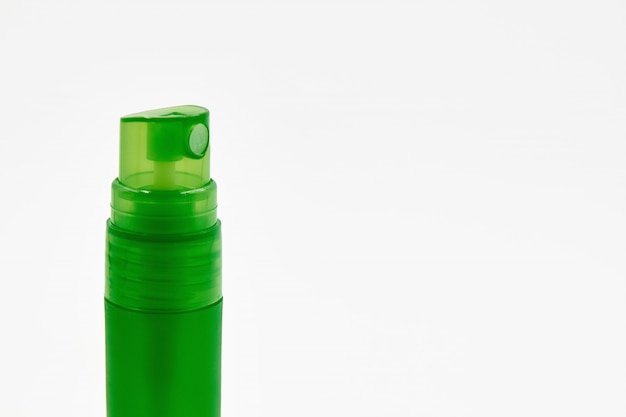 Frasco de spray de álcool verde. spray desinfetante sobre uma luz.