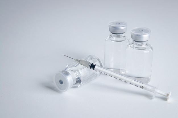Frasco de vacina antivírus com seringa Colocado em um fundo branco Conceito de vacina para o coronavírus