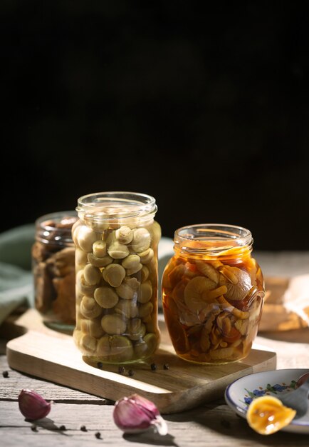 Frasco de vidro com cogumelos enlatados com alho e pimenta.