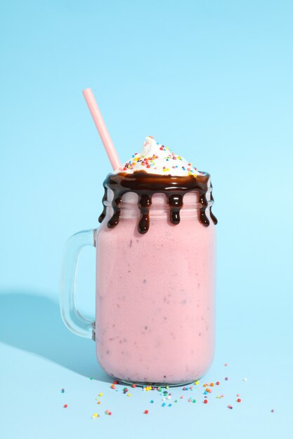 Frasco de vidro de milkshake delicioso berry em fundo azul