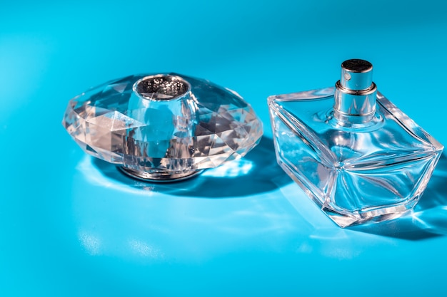 Foto frasco de vidro de perfume sobre fundo azul claro. eau de toilette