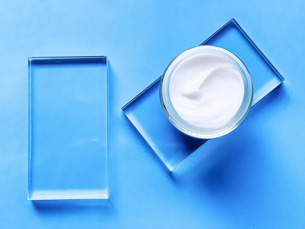 Frasco hidratante de creme facial em vidro e fundo azul, produto de beleza e ciência cosmética de cuidados com a pele