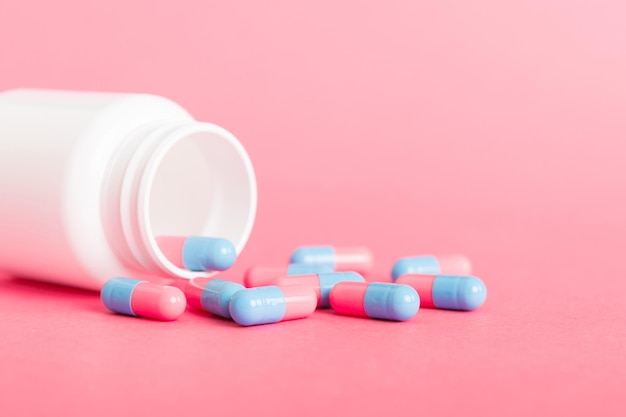 Frasco de medicina de plástico con cápsulas de pastillas sobre fondo de color Farmacia en línea Medicamentos analgésicos y concepto de resistencia a los antibióticos Industria farmacéutica