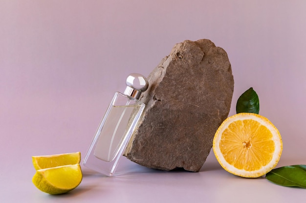 Frasco de perfume y composición con piedra natural y rodajas de limón presentación del aroma del perfume de mujer con notas de cítricos