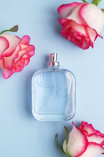 Frasco de perfume y flores de rosas Concepto de perfumes y cosméticos caros Fragancia floral para mujeres Aerosol de perfume