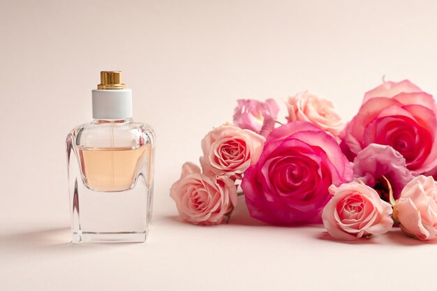 Frasco de perfume con flores sobre fondo claro