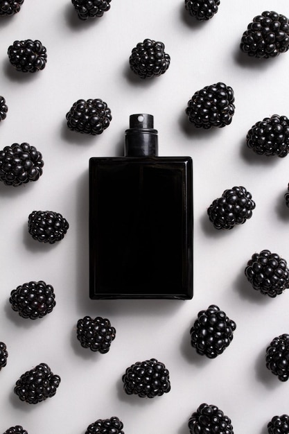 Frasco de perfume negro con moras Concepto de perfumes y cosméticos caros Esencia masculina