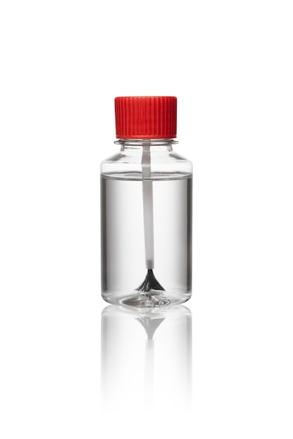 Frasco de química de vidrio con líquido transparente o solvente utilizado para la limpieza de etiquetas sobre fondo blanco Un equipo de laboratorio de ciencias para pruebas de laboratorio y experimentos Frasco con tapa roja y cepillo negro