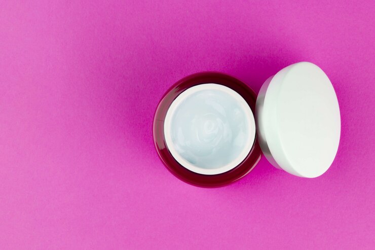 Foto frasco rosa con un gel de crema hialurónica hidratante para la cara de día ligero con una vista superior del espacio de copia