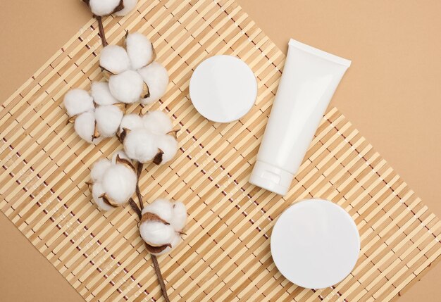 Frasco y tubos de plástico blancos vacíos para cosméticos sobre un fondo beige Embalaje para publicidad de suero de gel de crema y promoción de productos maqueta vista superior