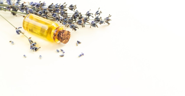 Frasco de vidrio de aceite esencial de lavanda o perfume de flores naturales con lavanda seca. Concepto de aromaterapia, cuidado de la piel, spa o masaje. Banner con espacio de copia