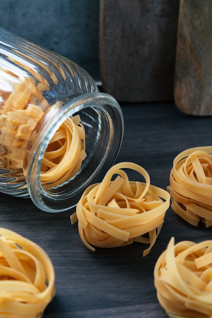 Frasco de vidrio acostado con pasta a su alrededor