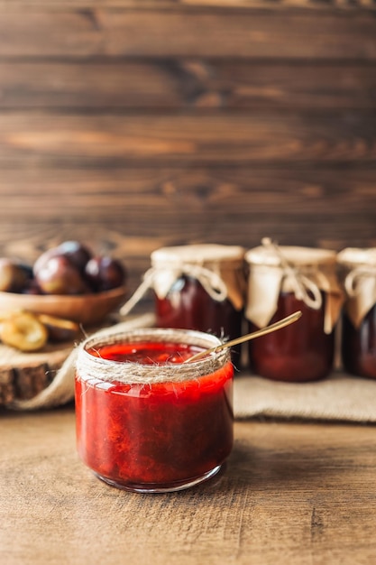 Frasco de vidrio con deliciosa mermelada de ciruela casera en la mesa