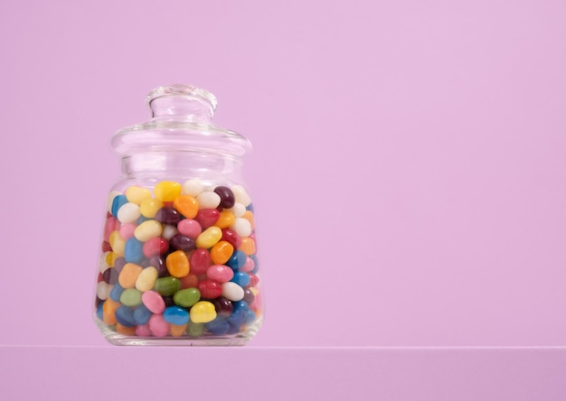 Un frasco de vidrio de dulces coloridos y deliciosos Copiar espacio para el texto