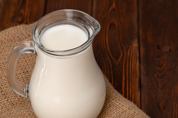 Frasco de vidrio de leche en la mesa de madera antigua cerrar