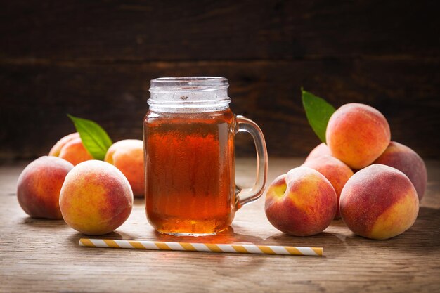 Frasco de vidrio de té helado de melocotón con frutas frescas