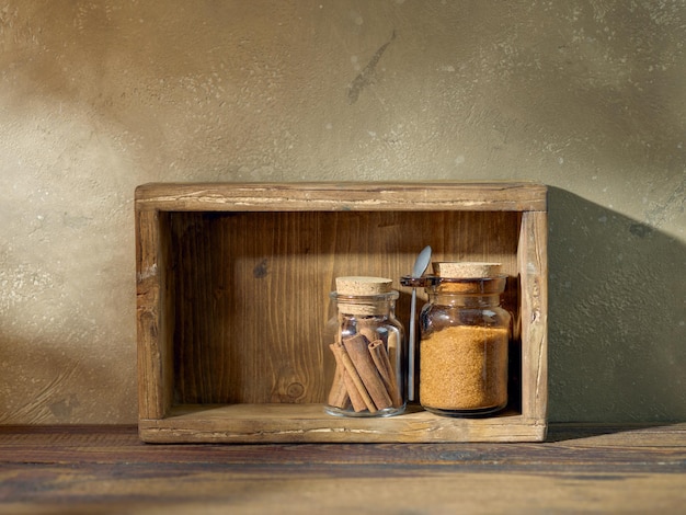 Frascos de almacenamiento de productos en una caja de madera sobre la mesa de la cocina