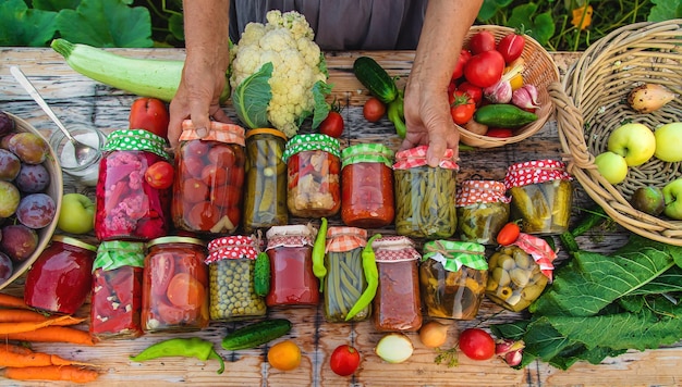 Frascos com legumes em conserva para o inverno Foco seletivo