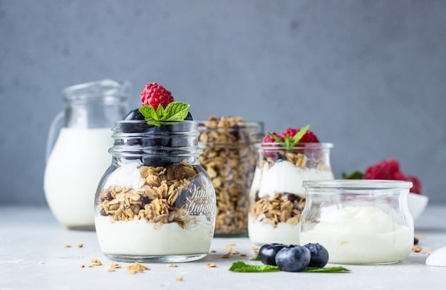 Frascos com parfait de granola, frutas e iogurte.