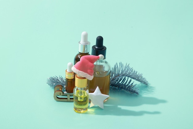 Frascos cuentagotas de aceite cosmético y suero y decoración navideña de vacaciones de invierno