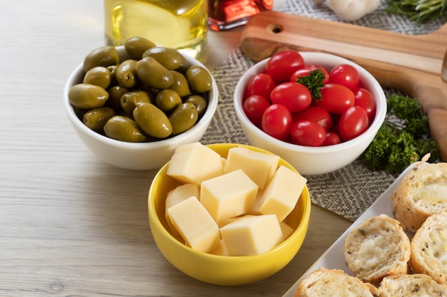 Frascos de aperitivo com queijo, azeitonas e tomate cereja.