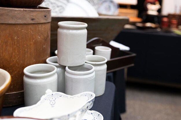 Foto frascos de cerâmica branca para produtos a granel em uma velha cômoda marrom em um mercado de antiguidades