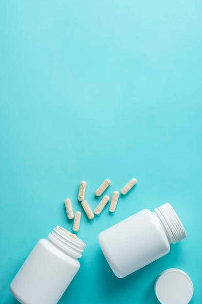 Frascos de comprimidos brancos sobre fundo azul Suplementos alimentares para cuidados de saúde vitaminas e medicamentos copiam o espaço
